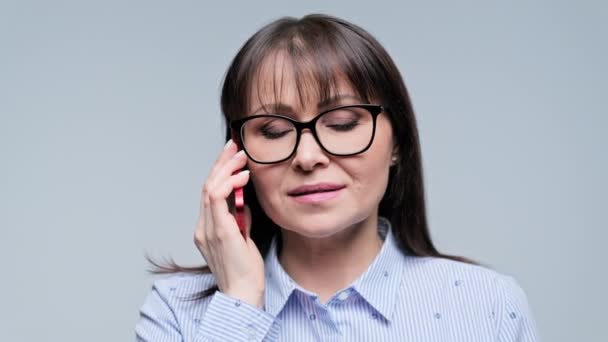 Kobieta Średnim Wieku Rozmawiająca Przez Telefon Szarym Tle Dojrzała Emocjonalnie — Wideo stockowe