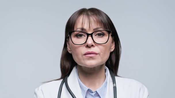 Gri Arka Planda Kendine Güvenen Orta Yaşlı Kadın Doktorun Yakın — Stok video