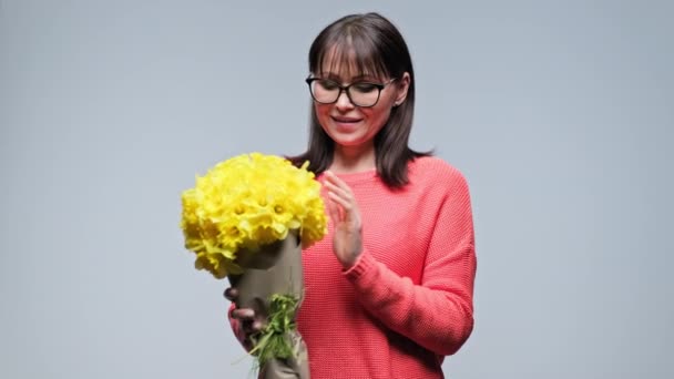 Щаслива Усміхнена Жінка Середнього Віку Букетом Жовтих Квітів Сіро Кольоровому — стокове відео