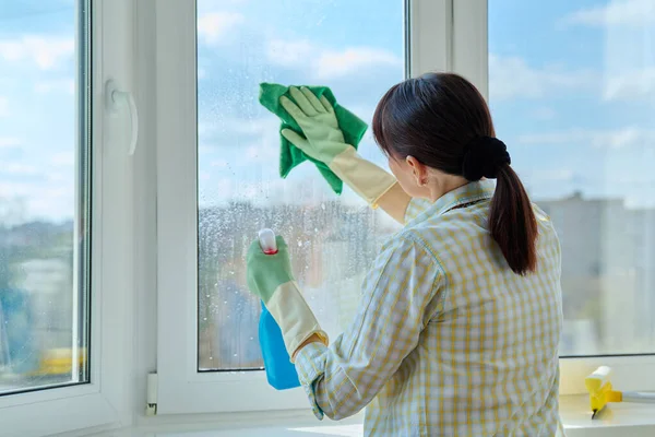 スプレーやマイクロファイバークロスを使用して自宅で女性のクリーニングウィンドウ 清潔感 サービスコンセプト — ストック写真
