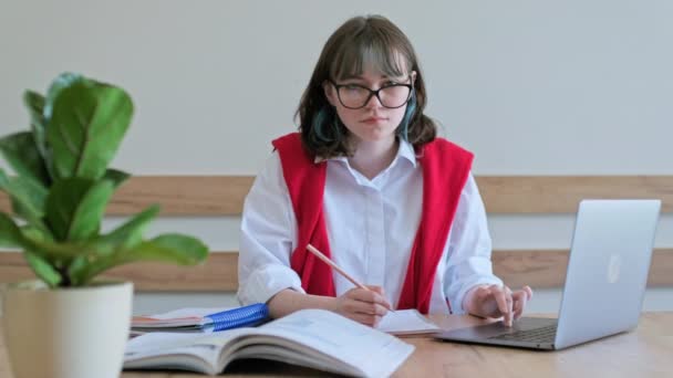 Nuori Naisopiskelija Istuu Kirjoituspöydän Ääressä Luokassa Käyttäen Kannettavaa Tietokonetta Kirjoja — kuvapankkivideo