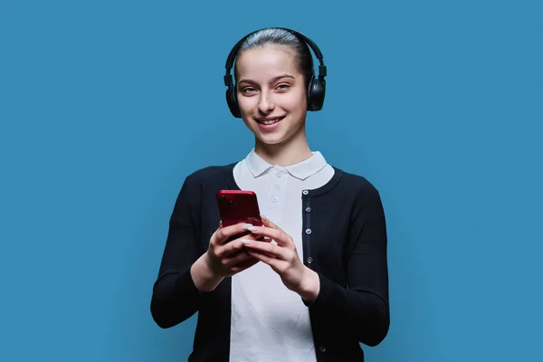 Mladá Žena Sluchátkách Poslech Audio Sledování Videa Smartphonu Modré Pozadí — Stock fotografie
