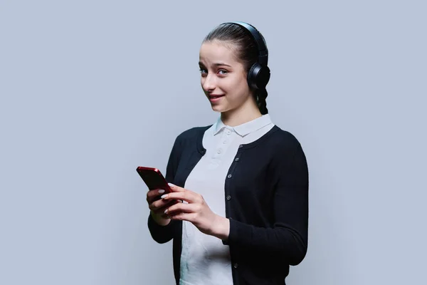 Mladá Žena Sluchátkách Poslech Audio Sledování Videa Smartphonu Šedé Pozadí — Stock fotografie