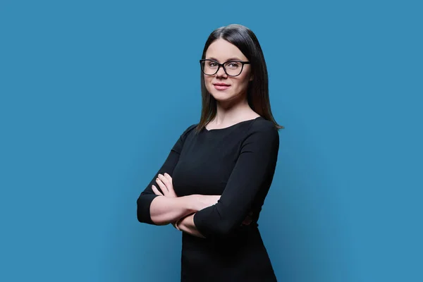 Porträtt Vacker Ung Kvinna Glasögon Svart Klänning Poserar Blå Studio — Stockfoto