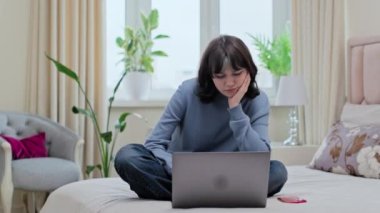 Sakin genç kız dizüstü bilgisayara bakıyor, evde yatağında, olumsuz haber hatası sorunu görüyor, agresif sinirle bilgisayarını kapatıyor.