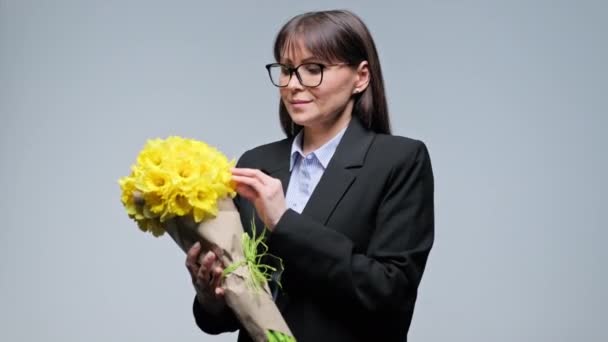 Szczęśliwy Uśmiechnięty Kobieta Średnim Wieku Bukietem Żółtych Kwiatów Szarym Tle — Wideo stockowe