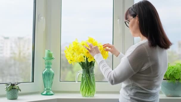 Зрелая Женщина Букетом Цветов Кувшине Окна Spring Yellow Seasonal Daffodils — стоковое видео