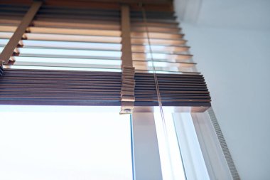 Kahverengi ahşap panjurlar iç cephede. Pencere dekorasyonu, ev, tarz, tasarım konsepti