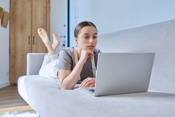 自宅のソファの上にラップトップを使用して横に10代の女の子 余暇コミュニケーション 現代生活 思春期の概念を学ぶための技術 — ストック写真