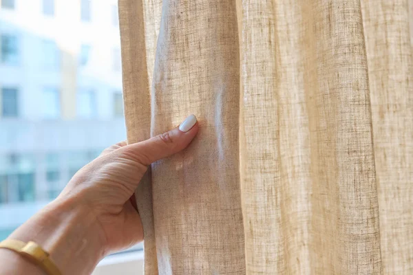 stock image Gray linen natural curtains on the window, close-up of a hand touching the curtains. Textile window decoration, fashion, style, design concept