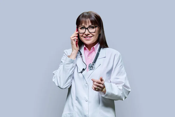 Medico Donna Matura Camice Bianco Che Parla Telefono Sfondo Grigio — Foto Stock