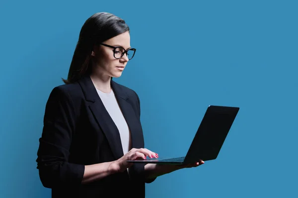 Młoda Bizneswoman Korzystająca Laptopa Tle Niebieskiego Studia Poważna Pewna Siebie — Zdjęcie stockowe