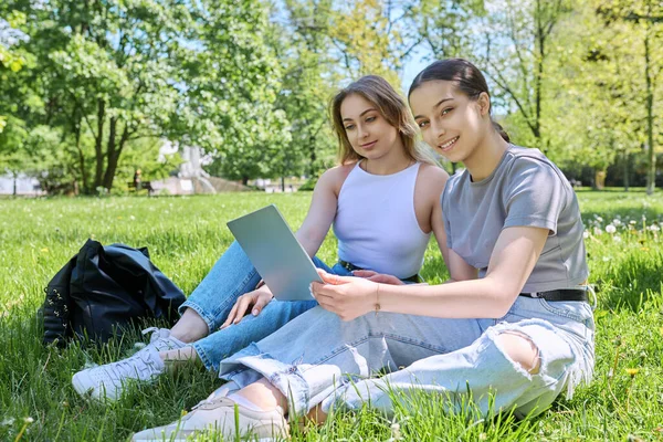 Genç Kız Lise Öğrencisi Çimlerin Üzerinde Oturmuş Dizüstü Bilgisayara Bakıyor — Stok fotoğraf