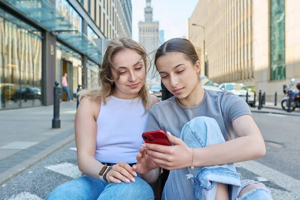 Δύο Χαμογελαστές Έφηβες Φοιτήτριες Smartphone Σύγχρονο Αστικό Στυλ Κτίρια Οδικό — Φωτογραφία Αρχείου