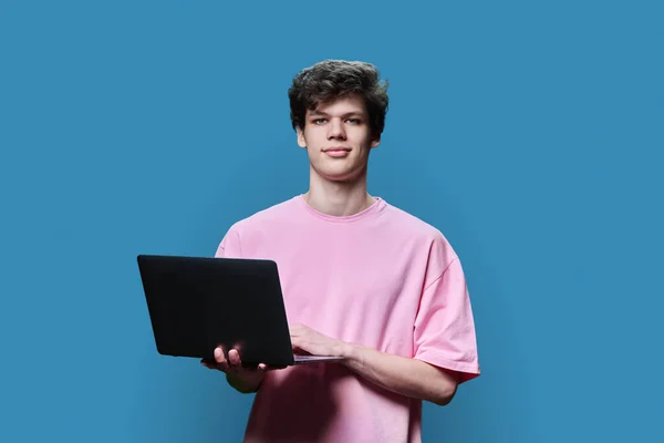 Νεαρός Φοιτητής Που Χρησιμοποιεί Φορητό Υπολογιστή Μπλε Φόντο Στούντιο Χαμογελώντας — Φωτογραφία Αρχείου