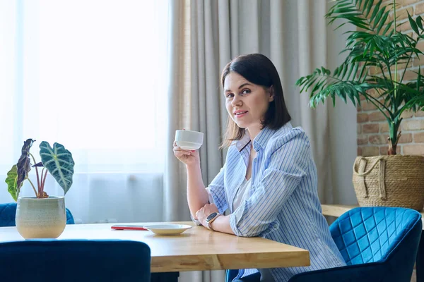Junge Frau Sitzt Mit Einer Tasse Kaffee Wohnzimmertisch — Stockfoto