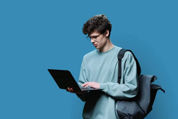 Fiatal Férfi Egyetemista Laptoppal Kék Háttérrel Jóképű Fickó Hátizsákkal Képernyőt — Stock Fotó