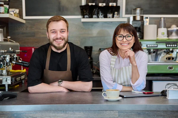 パートナー 笑顔の男性と女性のカメラを見て カウンターの近くのコーヒーショップで チーム 小企業 スタッフ カフェカフェテリアレストラン 起業家精神 — ストック写真