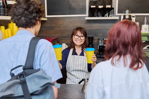 Female Coffee Shop Worker Serving Couple Young Customers Giving Paper — Stock Photo, Image