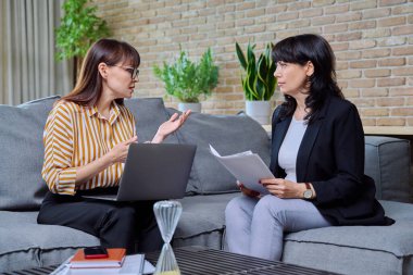 Toplantı odası, iki kendine güvenen olgun kadın koltukta oturmuş, konuşuyor, iş tartışıyorlar. İş, finans, lojistik, hukuk, satış kavramı