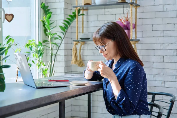 Жінка Середнього Віку Каву Дивлячись Екран Ноутбука Сидячи Столом Кафе — стокове фото