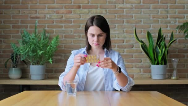若い女性は 表に座って オメガ3ビタミン 栄養補助食品のブリスターを保持し タラ肝油カプセルを服用 健康皮膚の爪 — ストック動画
