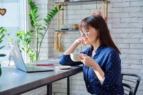 Middle Aged Woman Drinking Coffee Looking Laptop Screen Sitting Table — Stock Photo, Image