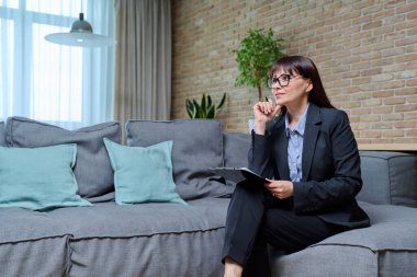 Kendine güvenen olgun kadın psikolog psikoterapist psikoterapistin portresi kanepede oturuyor, koltukta oturuyor. Ruh sağlığı tedavisi terapisi, yardım, destek