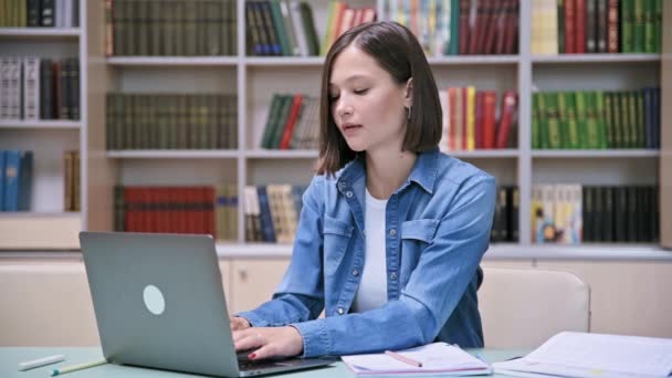 図書館で勉強する若い女子大学生 ラップトップコンピュータにタイピング 大学のコンセプト — ストック動画