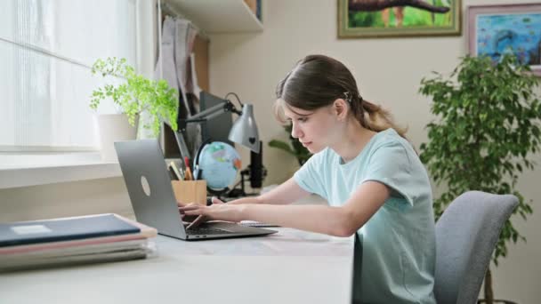 Preteen Girl Studiert Hause Schreibtisch Und Tippt Auf Dem Laptop — Stockvideo
