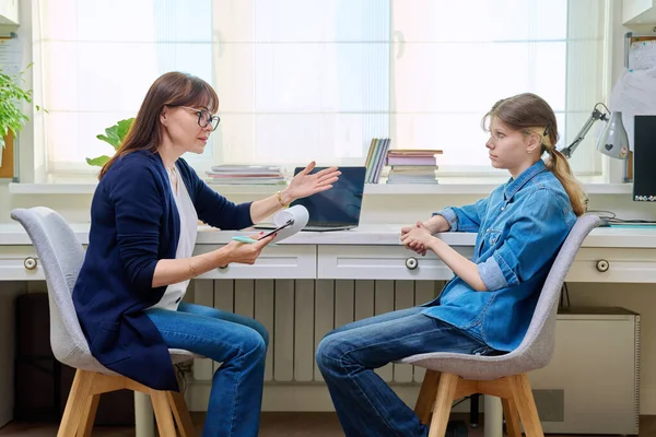 stock image Sad teenage girl at therapy meeting with psychologist, counselor. An upset girl, high school student, sitting in mental specialists office. Child psychology, psychotherapy, social life of teenager