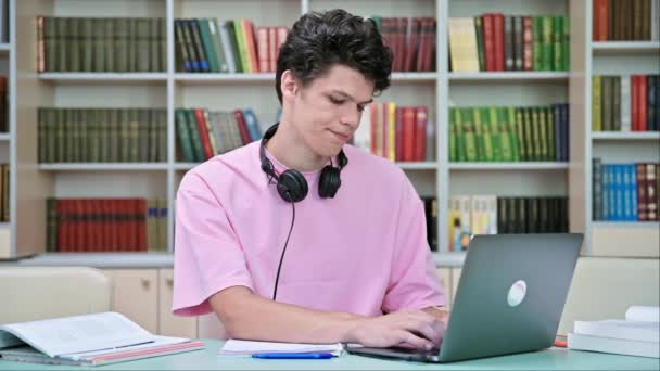 Молодой Студент Сидящий Ноутбуками Библиотеке Колледжа Парень Лет Наушниками Печатающими — стоковое видео