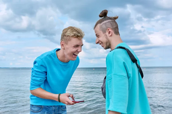 Dos Amigos Riendo Jóvenes Alegres Con Teléfono Inteligente Fondo Playa —  Fotos de Stock