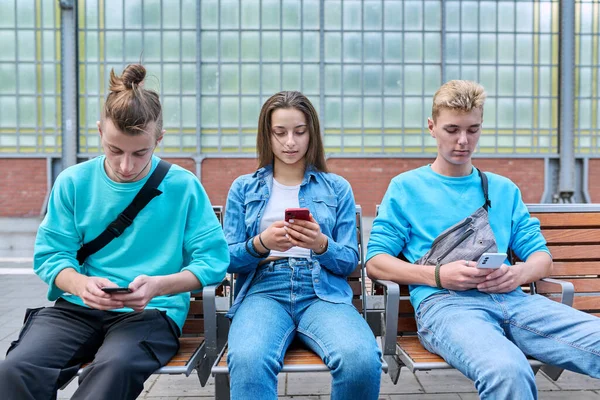 Grupo Amigos Adolescentes Usando Smartphones Sentados Cadeiras Plataforma Estação Ferroviária — Fotografia de Stock
