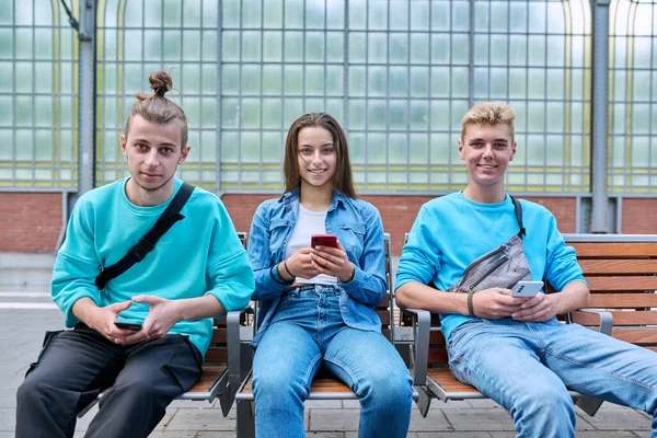 Bir Grup Genç Arkadaş Tren Istasyonundaki Sandalyelerde Oturan Akıllı Telefonları — Stok fotoğraf