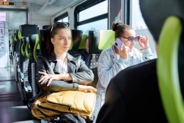 Banliyö treni yolcuları, sırt çantalı genç kız ders çalışmaya gidiyor. Şehirlerarası elektrik demiryolu taşımacılığı kavramı