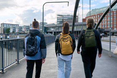 Sırt çantalı üç lise öğrencisinin şehirde birlikte yürüdüğünü görüyorum. Gençlik, arkadaşlık, eğitim, kentsel yaşam tarzı kavramı