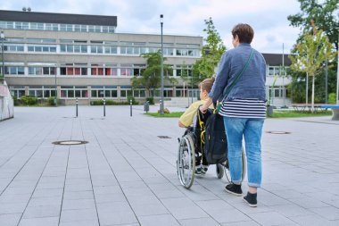 Okul binasının yakınındaki tekerlekli sandalyede oturan bir kadının arka görüntüsü, kopyalama alanı. Çocuklar, engellilik, eğitim, etkinlik, sağlık, yaşam tarzı kavramı