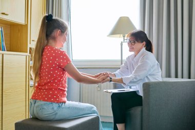 10 yaşında bir kız çocuğu psikologla terapi seansında. Okul danışmanı çocukla konuşuyor, dinliyor, sorunlara yardım ediyor. Ruh sağlığı, çocukluk, okul çocukları, psikoloji, psikoterapi