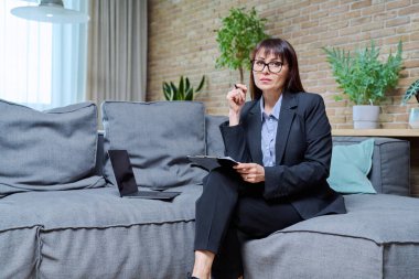 Kendine güvenen olgun kadın psikolog psikoterapist psikoterapistin portresi kanepede oturuyor, koltukta oturuyor. Ruh sağlığı tedavisi terapisi, yardım, destek