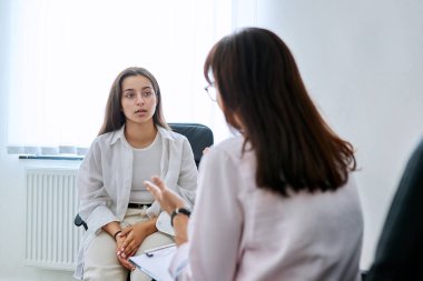 Okul danışmanı genç kız öğrenciyle konuşuyor. Ergen sosyal hizmet görevlisi, akıl sağlığı, ergenlik, psikoloji, psikoterapi, danışmanlık, terapi, profesyonel destek
