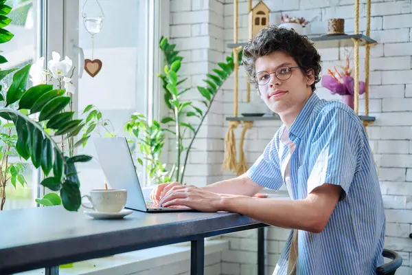 年轻的大学生坐在咖啡店的笔记本电脑上 边喝咖啡边打字 互联网在线技术促进休闲 生活方式概念 — 图库照片