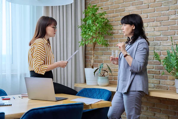 Dwie Dojrzałe Biznesmenki Pracujące Razem Biurze Poważnie Ufne Kobiety Rozmawiają — Zdjęcie stockowe