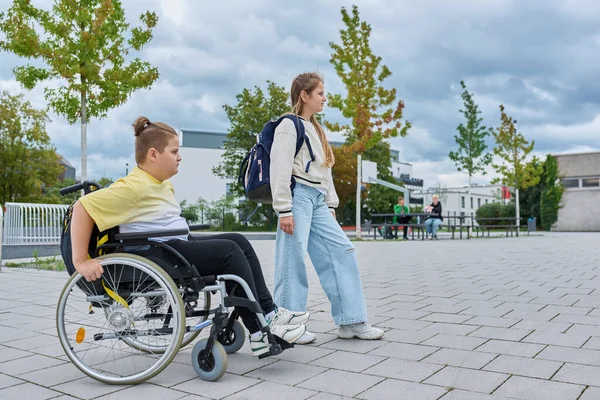 Çocuklar birlikte okula gidiyor, tekerlekli sandalyedeki çocuk, sırt çantalı kız. Eğitim, arkadaşlık iletişimi, okul, engellilik, kapsayıcılık kavramı