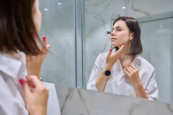 여자가 화장실 거울에서 그녀의 얼굴을 아름다움 메이크업 — 스톡 사진