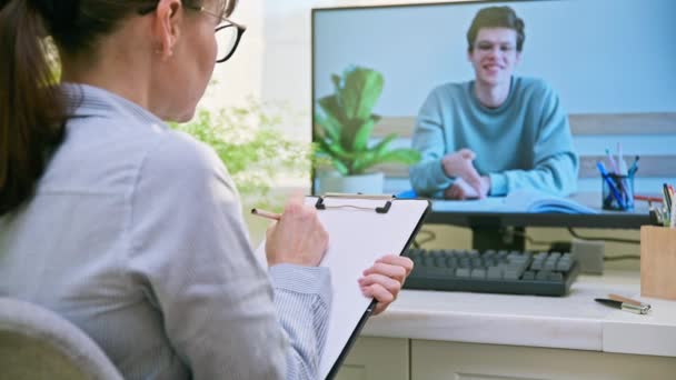 女心理医生在网上为未成年男生提供咨询 心理治疗师有视频电话会议 有人在电脑屏幕上说话 治疗课 心理心理治疗精神健康 — 图库视频影像