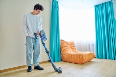 Genç adam evi süpürüyor. Temizlik, temizlik, hijyen, gençlik konsepti