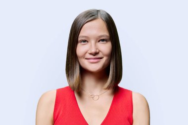 Doğal makyaj modasına uygun burun delici takılar beyaz arka planda parlak, sağlıklı düz saçlar olan genç bir kadın yüzü. Modaya uygun kaşlar kirpikler dudaklar güzel hippi kadınlar. Güzellik moda bakımı