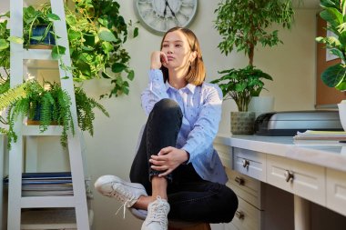 Mutsuz üzgün üzgün genç kadın evde yalnız oturuyor. Depresif, endişeli, yalnız, dalgın, endişeli 20 'li yaşlarda bir kadın. Stres, depresyon, duygu, sorunlar, gençlik, zihinsel sağlık kavramı