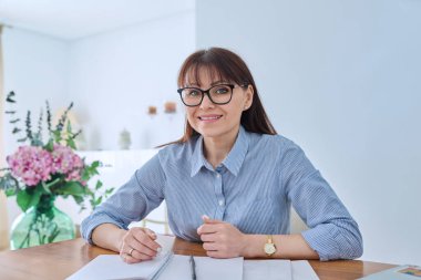 Webcam 'de yetişkin bir iş kadınının webcam' e bakıp görüntülü sohbet görüşmesi yaptığı görülüyor. Kendine güvenen 40 'ların kadın finansör yöneticisi avukat öğretmen eğitmeni ev ofisinde çalışıyor.